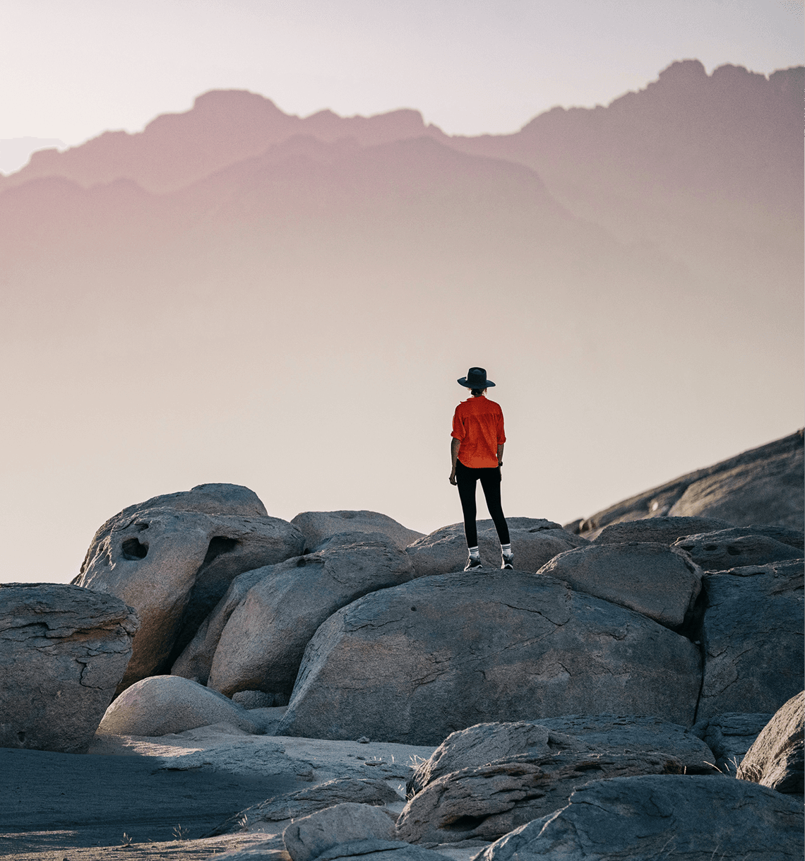 Traveler standing on rocks overlooking a mountain range